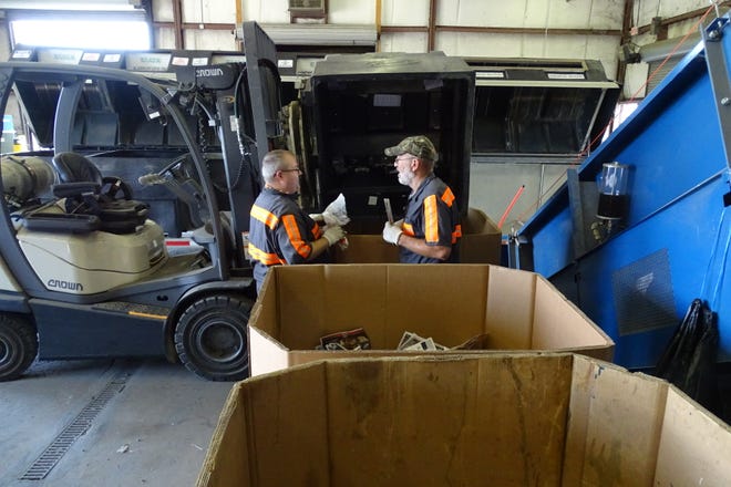 Steve Cazzell, left, and Randy Burton sort items from a recycling trailer Thursday at the Crawford County Recycling Center.