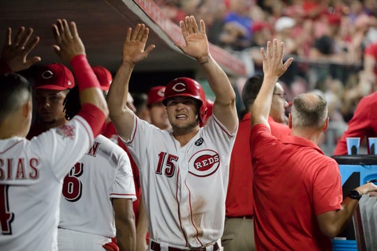 Cincinnati Reds third baseman Nick Senzel (15) celebrates with teammates after scoring the tying run in the eighth inning of the MLB baseball game against Milwaukee Brewers on Tuesday, July, 2, 2019, at Great American Ball Park in Cincinnati. Cincinnati Reds defeated Milwaukee Brewers 5-4 in 11 innings. 