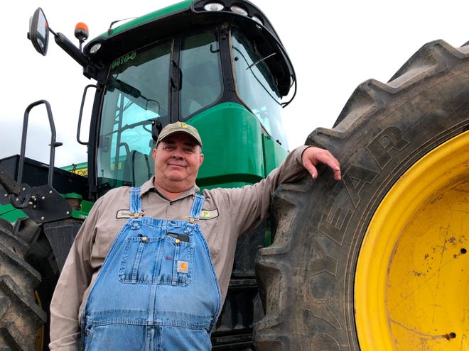 In this Thursday, June 20, 2019, photo, farmer Bernard Peterson leans on a tractor at his farm in Loretto, Ky. When the Trump administration announced a $12 billion aid package for farmers struggling under the financial strain of his trade dispute with China, the payments were capped, but many large farming operations found legal ways around the limits. (AP Photo/Dylan Lovan)