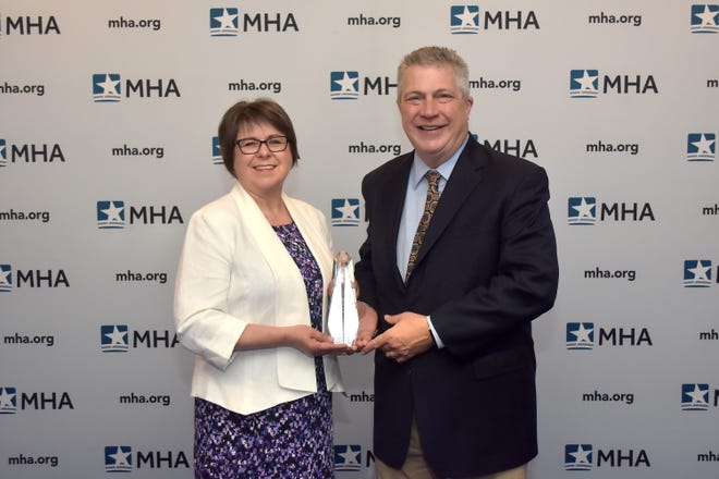 Michaeline Raczka, RD, director of Community Health at St. Mary Mercy Livonia, and David Spivey, president and CEO of St. Mary Mercy Livonia, accept The Michigan Health and Hospital Association's 2019 Ludwig Community Benefit Award on behalf of Healthy Livonia.
