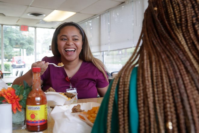 Amina Cordova laughs with her friend Megan Monroe as the two meet during their lunch breaks at Olean's Cafe Wednesday, July 3, 2019.