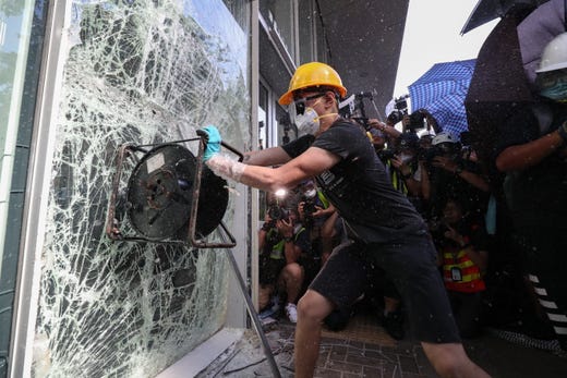 A protester breaks a window of the Legislative Council in Hong Kong, China, on July 1, 2019. Protesters are demanding the resignation of Hong Kong Chief Executive Carrie Lam and the full withdrawal of a suspended extradition bill. On July 1, Hong Kong marks the 1997 transfer of sovereignty of Hong Kong from Britain to China.