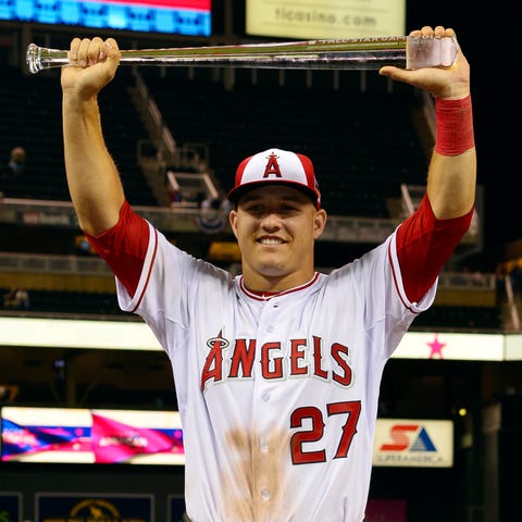 Mike Trout of the Los Angeles Angels holds up the...