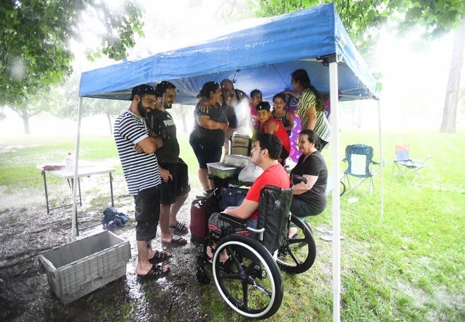Members of the Ghazala family aren't budging despite a heavy rain fall that went through Clawson on Thursday afternoon during the annual Fourth of July festival.