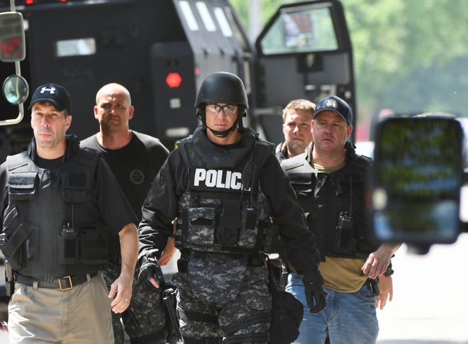 Police wear tactical gear as they deal with a barricaded suspect in St. Clair Shores on Friday, July 5, 2019.
