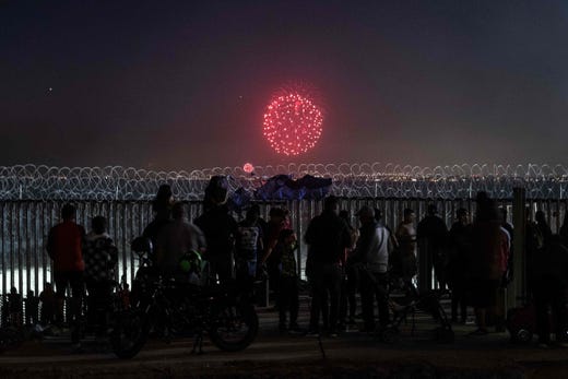 People gather on the Mexican side of the US-Mexico border fence to watch the Fourth of July fireworks being shot on the other side on the San Diego Bay, in Playas de Tijuana, Mexico on July 4, 2019.