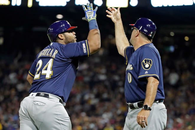 The Brewers' Jesus Aguilar rounds third to greetings from third base coach Ed Sedar after hitting a two-run home run during the eighth inning.