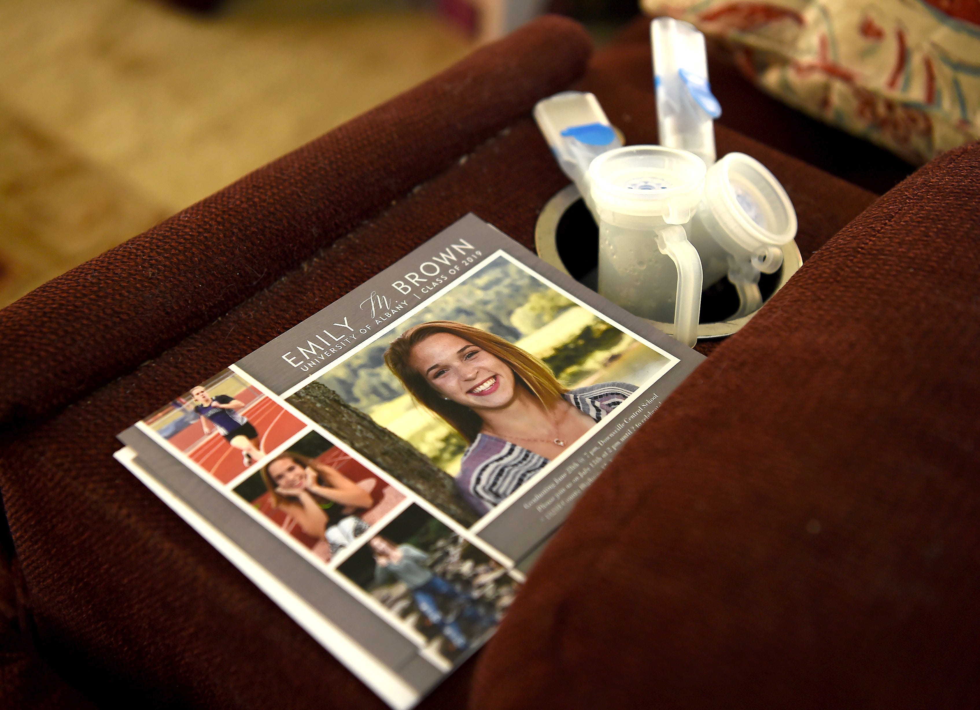 Emily Brown's graduation announcement sits next to a medical device in her East Branch home. Emily, an athlete who was born with cystic fibrosis, will be attending University of Albany in the fall and running on the track team. Friday, June 28, 2019.