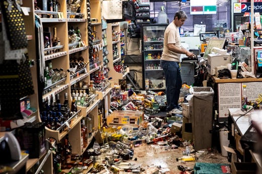 An employee, Sam stands behind the counter amid fallen bottles that smashed on the ground after an earthquake, at a gas station and liquor store in Ridgecrest, Calif. on July 6, 2019. A 7.1 magnitude earthquake, the second hitting in as many days, located in the same area some 11 miles from Ridgecrest and 150 miles North of Los Angeles shook Southern California on July 5.