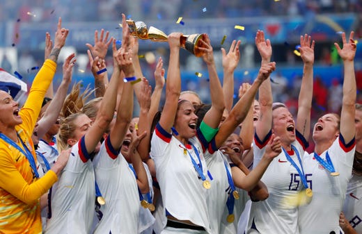 United States forward Alex Morgan (13) hoists the World Cup trophy and celebrates with teammates after defeating the Netherlands in the championship match of the FIFA Women's World Cup France 2019 at Stade de Lyon.