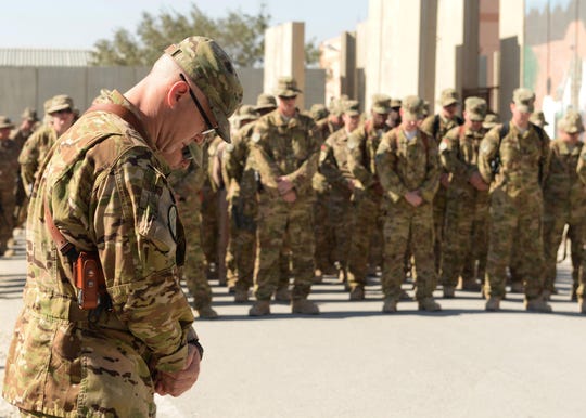 Lt. Col. Mitchell Spillers, 774th Expeditionary Airlift Squadron commander, bows his head during a moment of silence during a fallen comrade memorial ceremony held in honor of six Airmen Oct. 3, 2015, at Bagram Airfield, Afghanistan.