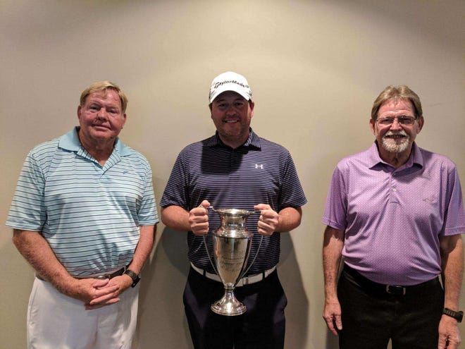 Steve Grimes, left, and John Grimes right, honorees at this year's Marion County Men's Amateur Golf Championships, present overall winner Alan Dixon with the trophy.