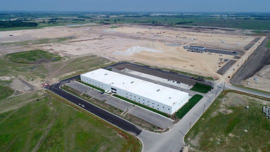 A multipurpose building (front) is up and a display-panel factory that will include multiple buildings is under construction on a pad of crushed, compacted gravel at Foxconn Technology Group's planned manufacturing complex Tuesday in Mount Pleasant.