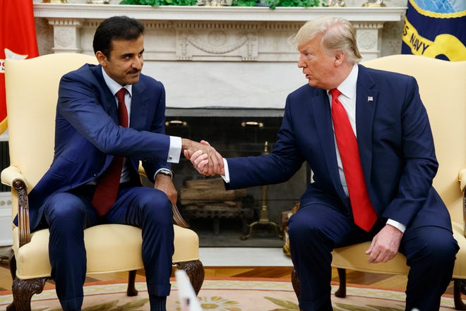 President Donald Trump shakes hands with Qatar's Emir Sheikh Tamim Bin Hamad Al-Thani in the Oval Office of the White House, Tuesday, July 9, 2019, in Washington.