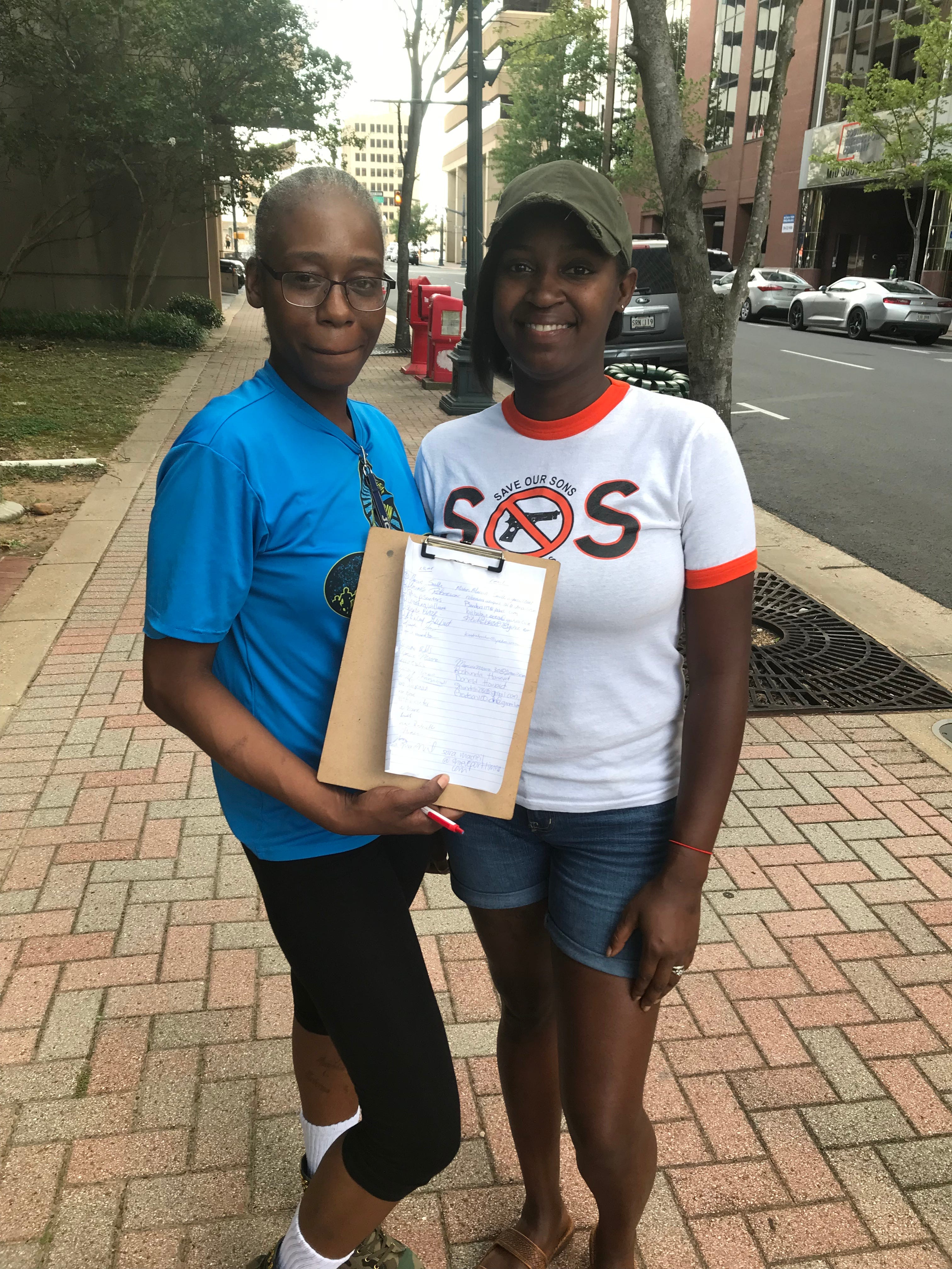 Amaelie Roberson and Beatricious Foster gathered signatures in support of equal employment opportunities for felons Monday.