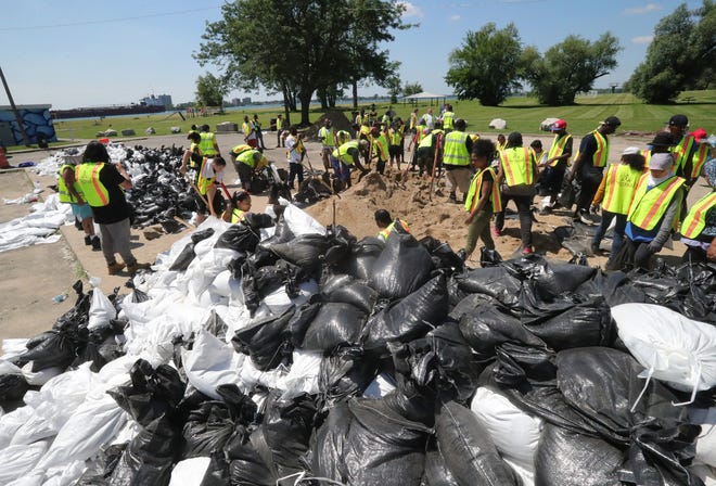 Volunteers fill sandbags at Alfred Brush Park to place along canals in the Jefferson Chalmers neighborhood. The area is being flooded by the rising Detroit River Thursday, July 11, 2019 in Detroit, Mich.