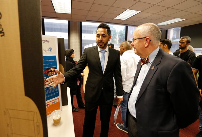 Missouri State University English Language Institute student Ali Alalqam presents his research project to MSU President Clif Smart during a reception at the Meyer Alumni Center on Thursday, July 11, 2019.