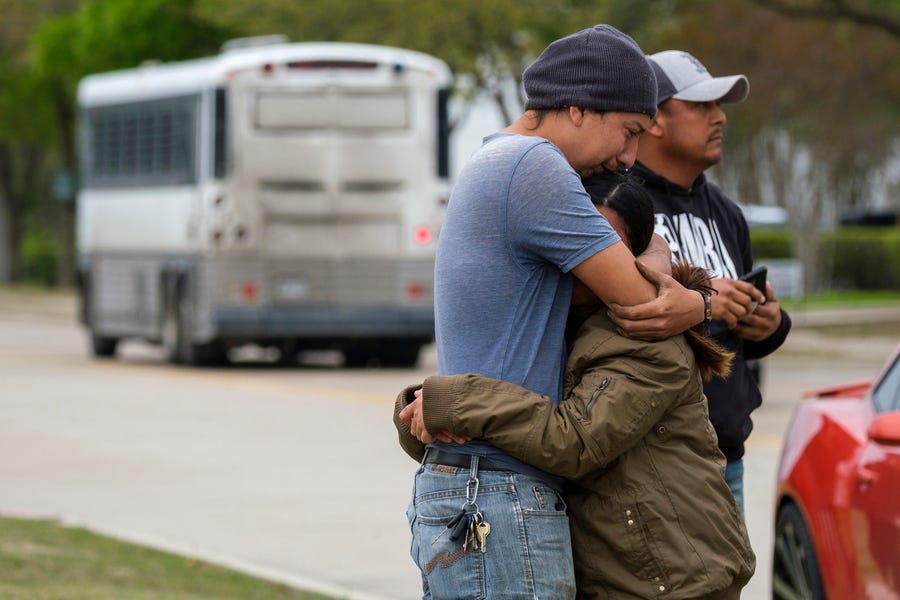 A couple embrace as a bus from LaSalle Corrections Transport departs Allen, Texas. Immigrant families and advocates warned about planned arrests around the country by the Immigration and Customs Enforcement agency.
