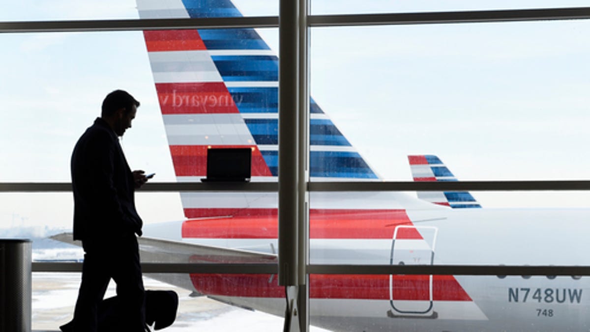 A passenger talks on the phone as American Airlines jets sit parked at their gates at Ronald Reagan Washington National Airport in Arlington, Va., on Jan. 25, 2016.