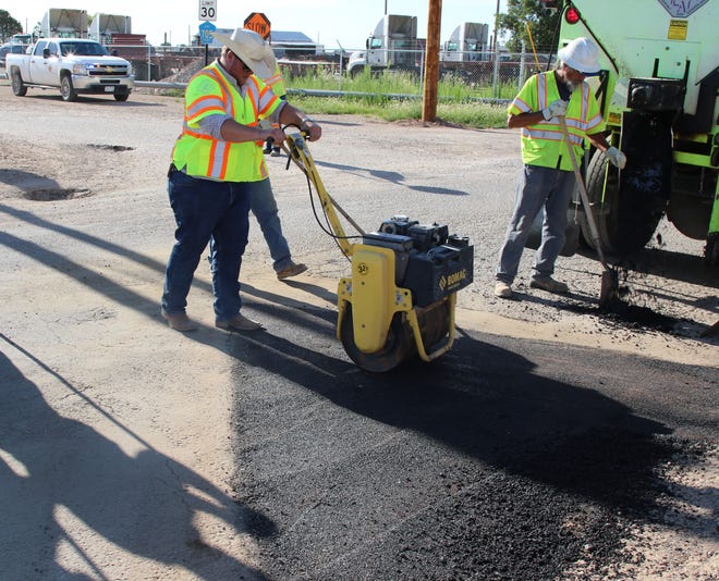 Eddy County Public Works Director Jason Burns smooths freshly poured pavement July 10.