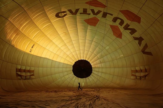 A person walks inside a hot air balloon shell as it is inflated before taking off during the 23rd European Balloon Festival in Igualada, Spain, July 11, 2019.