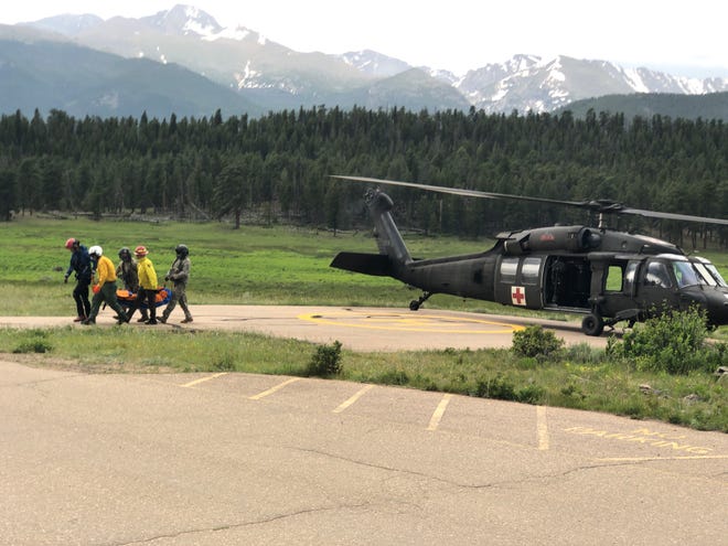 Rocky Mountain National Park search and rescue members at Upper Beaver Meadows carry an injured hiker who fell 75 feet in The Trough section of Longs Peak on Friday.