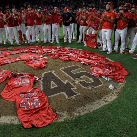 The Angels lay their jerseys on the mound to pay...