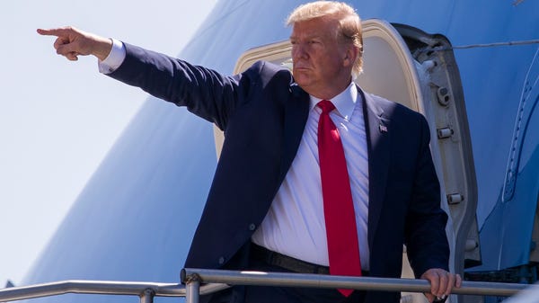 President Donald Trump points while boarding Air...