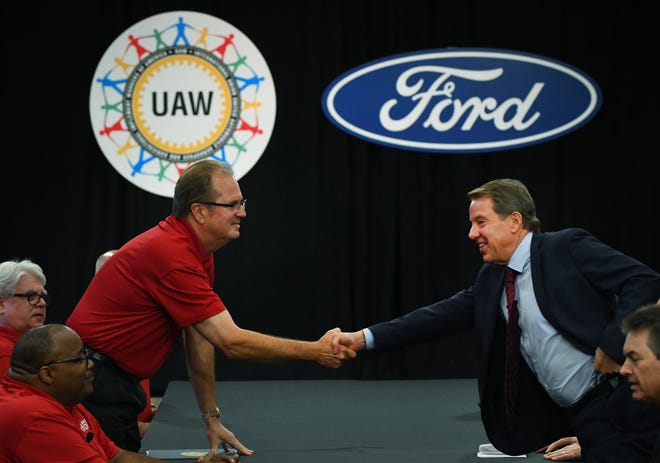 United Auto Workers President Gary Jones, left, and Ford Executive Chairman Bill Ford Jr.  shake hands to open contract negotiations Monday at Ford headquarters.