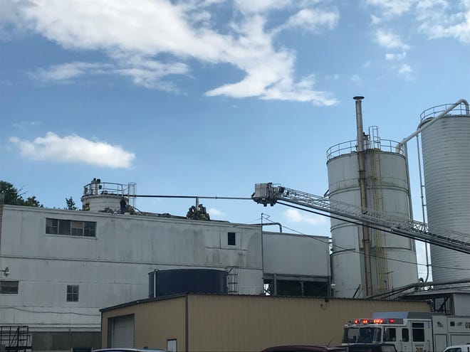 Licking County firefighters saw through a portion of the roof at Tectum Inc., a company in Newark, on Monday, July 15, 2019.