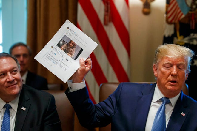 Secretary of State Mike Pompeo, left, looks at a paper held by President Donald Trump about Rep. Ilhan Omar, D-Minn., as Trump speaks during a Cabinet meeting in the Cabinet Room of the White House, Tuesday, July 16, 2019, in Washington.
