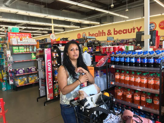 Family Dollar store customer Andrea Botiller shops despite the lack of air conditioning.