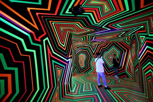 People take souvenir photos inside the installation 'Fading colors and Glow' by the Berlin base art group 'Tape That' during an art exhibition in Taipei, Taiwan on July 16, 2019.