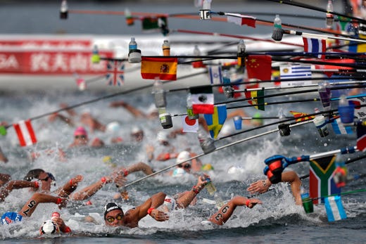 Swimmers reach for drink bottles while competing in the men's 10km open water swim at the World Swimming Championships in Yeosu, South Korea on July 16, 2019.