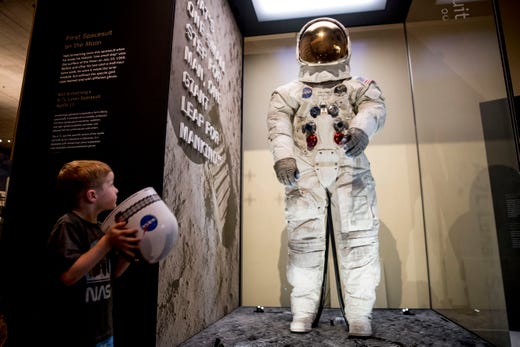 Jack Heely, 5, of Alexandria, Va., plays with a toy space helmet as he arrives as one of the first visitors to view Neil Armstrong's Apollo 11 spacesuit after it is unveiled at the Smithsonian's National Air and Space Museum on the National Mall in Washington on July 16, 2019.