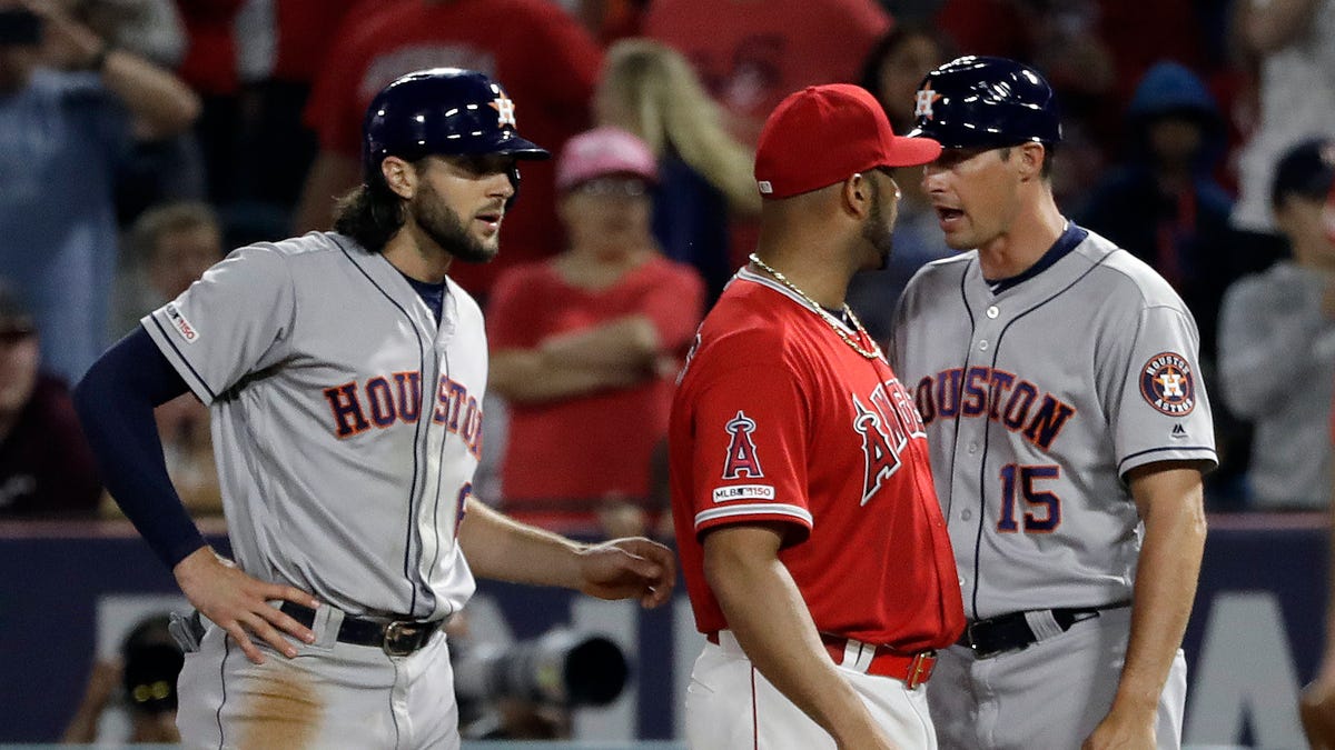 Los Angeles Angels first baseman Albert Pujols, center, argues with Houston Astros first base coach Don Kelly (15) after Astros' Jake Marisnick, left, was hit by a pitch during the sixth inning.