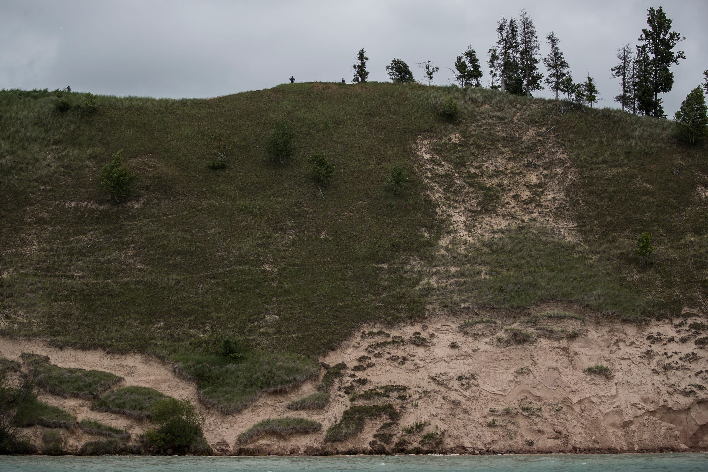 Golfers stand near the 12th hole tee box of Arcadia Bluffs Golf Club in Arcadia Township, Thursday, July 11, 2019.