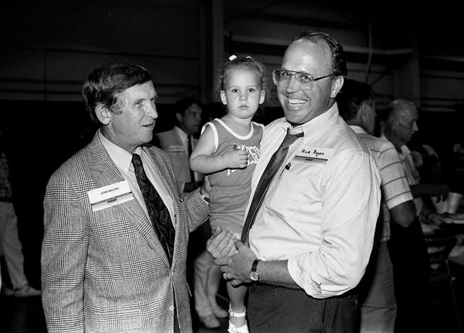 Rick Regen, right, and niece Hannah Regen, 2, of Nashville, greet Tennessee head football coach Johnny Majors during the UT Picnic at the National Guard Armory in Nashville on July 27, 1989.
