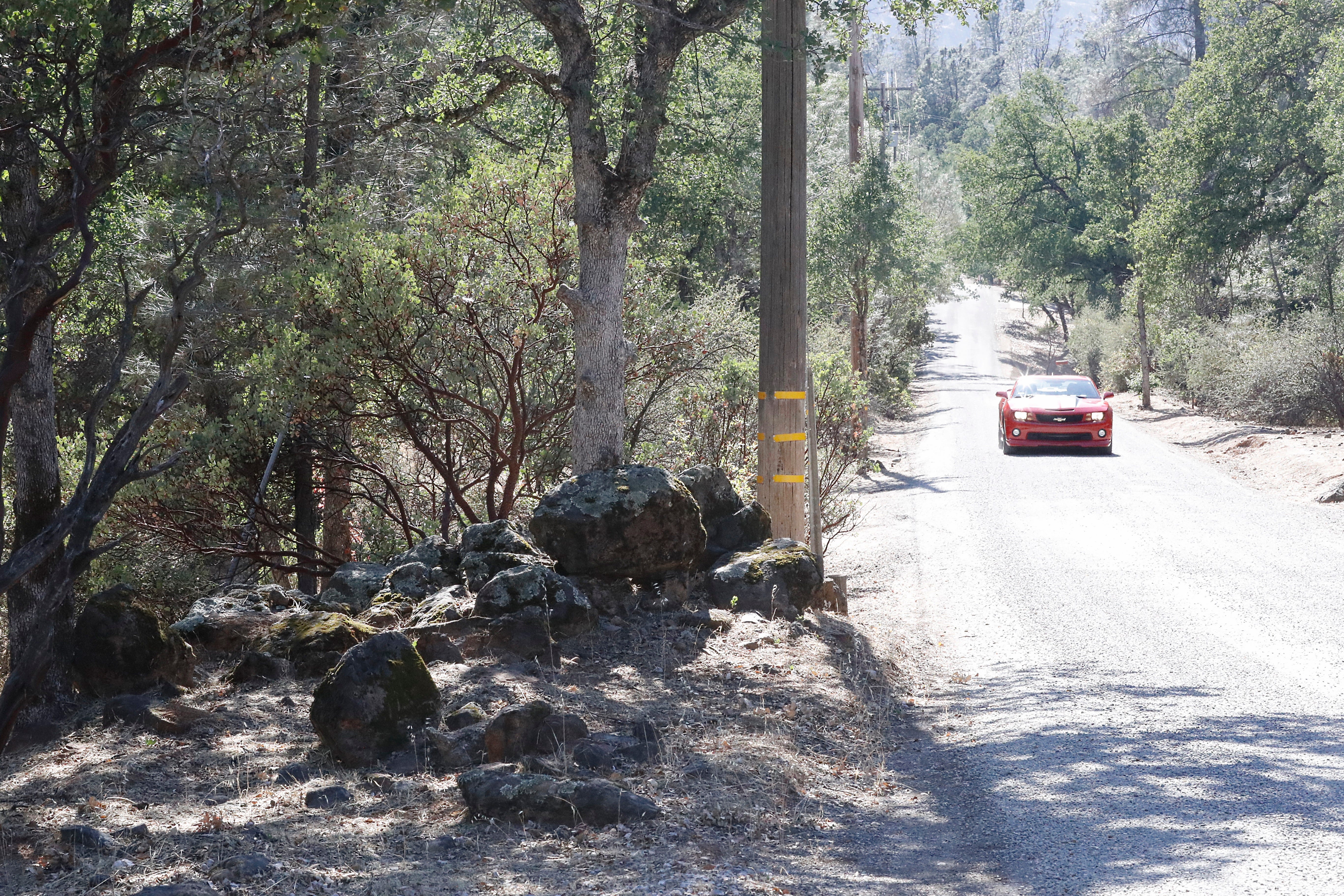 A car drives down Trail Drive where land managed by the Bureau of Land Management sits next to homes.