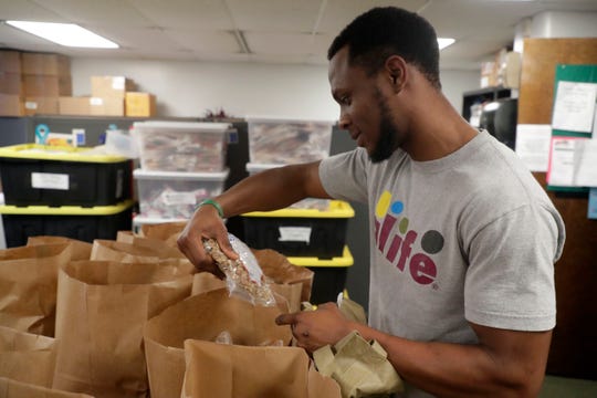 Sean Fisher, a FAMU student, sorts through the food items that he can pick from in the FAMU food pantry Thursday, July 18, 2019. 