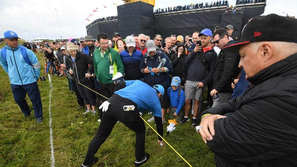 July 18: Rory McIlroy retrieves his ball on the...