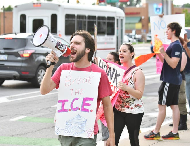 Robert Jay of Occupy ICE Detroit leads chants on the bullhorn while protesting an immigration crackdown in front of the ICE Detroit Field Office in Detroit on July 19.