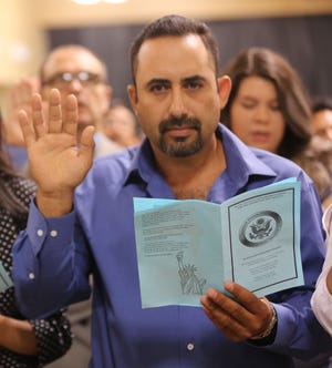 A man pledges an oath to the United States during a naturalization ceremony, Friday July 19, 2019, at the Las Cruces Convention Center.