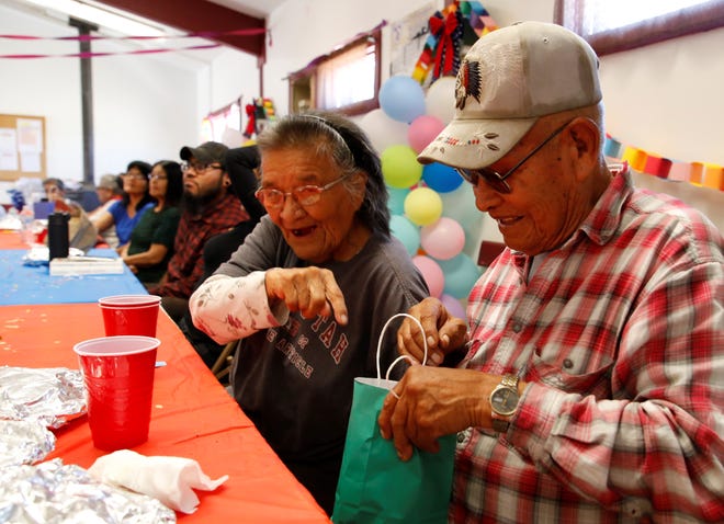 Bessie Napoleon, left, reacts to Edward Smith winning a door prize at a luncheon on July 18 to recognize the elderly and veterans at the Gadii'ahi-To'koi Chapter house.