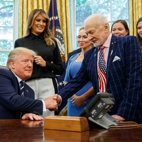 President Donald Trump shakes hands with Apollo...
