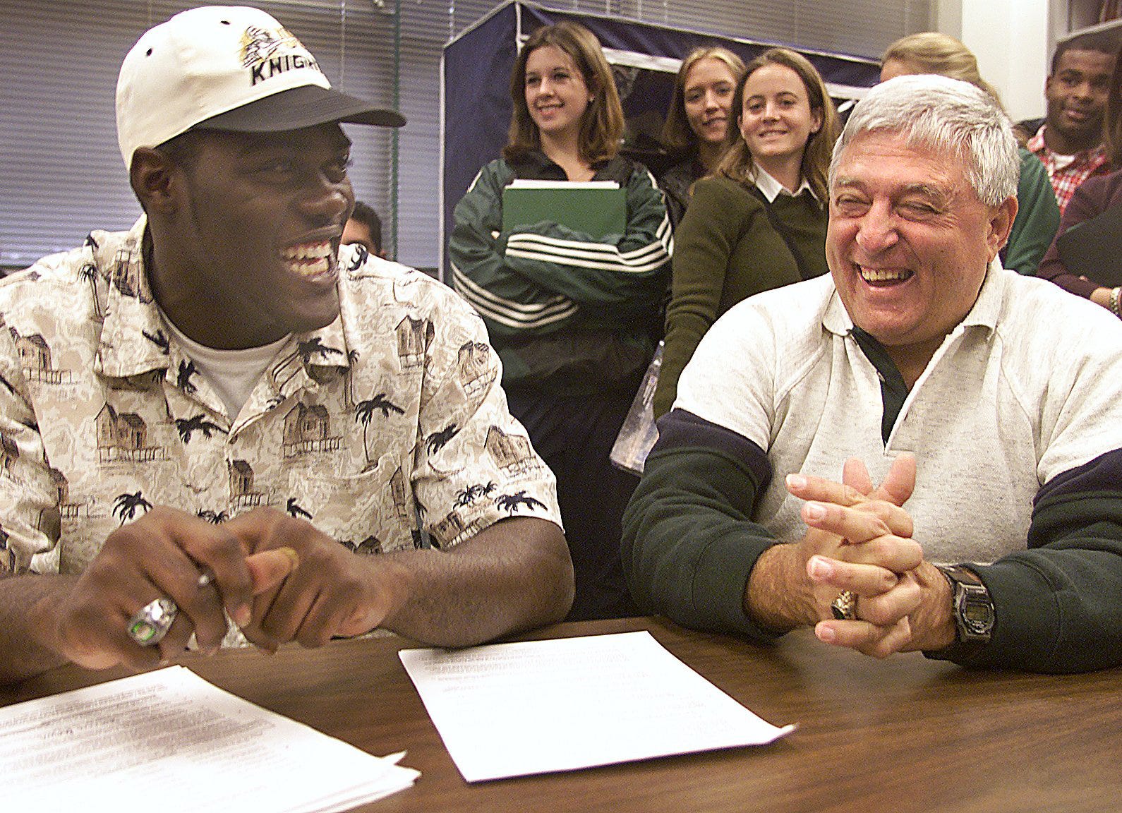 Fort Myers High School football player Savarris Brown, left, shares a laugh with head coach Sam Sirianni Sr. after signing his letter of intent to play college football in 2000.