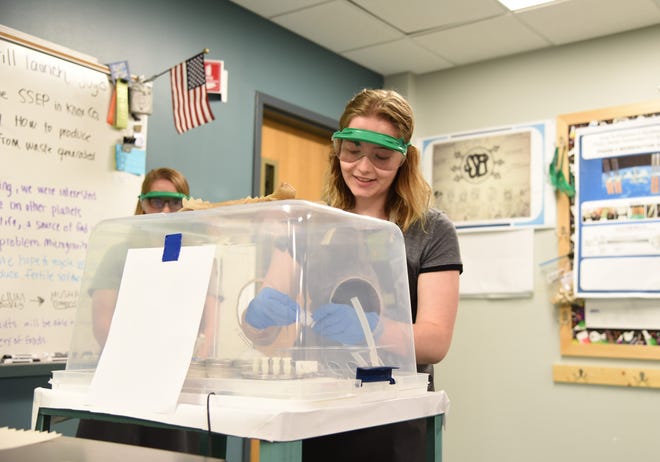 Elizabeth Randolph, senior at Career Magnet Academy, working on an experiment in the classroom, while wearing protective gear.