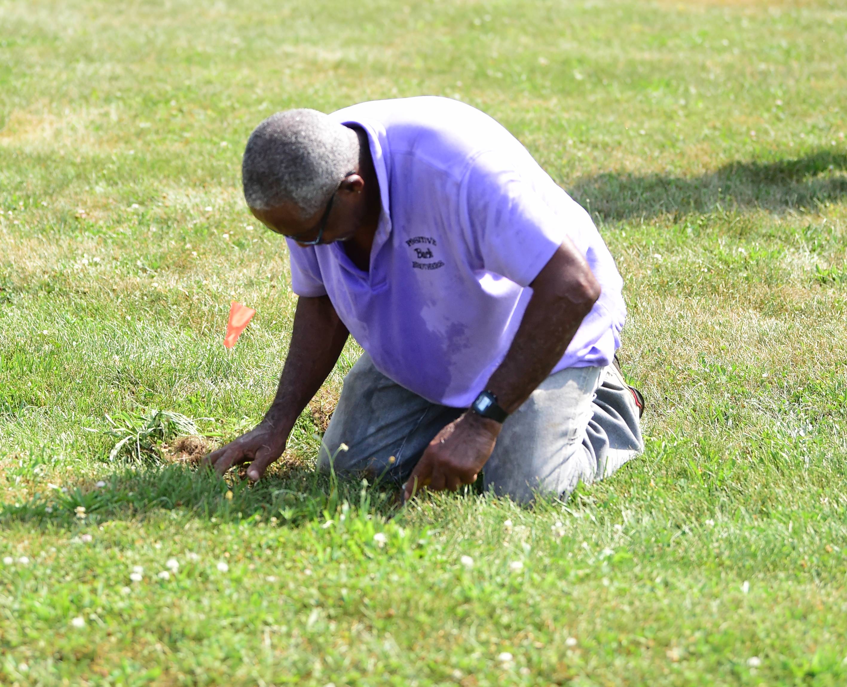 A volunteer works to uncover graves at Lebanon Cemetery in York County in 2019.
