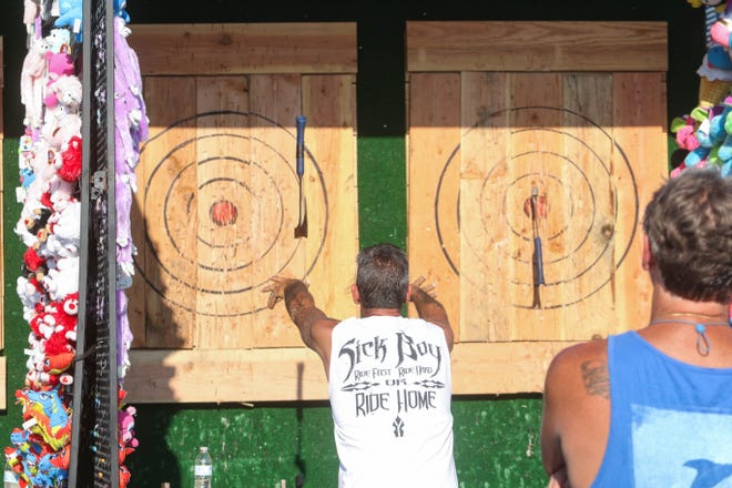 Axe throwing is a fun activity to do right now. Friends are pictured throwing axes at the Delaware State Fair during its 100th year in operation on July 19, 2019.