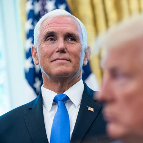 Vice President Mike Pence listens as President Don